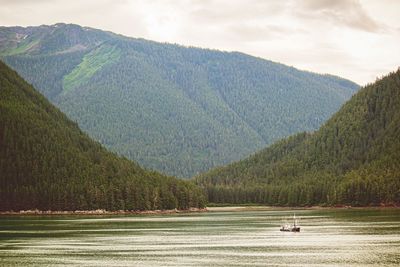 Scenic view of lake by mountains against sky