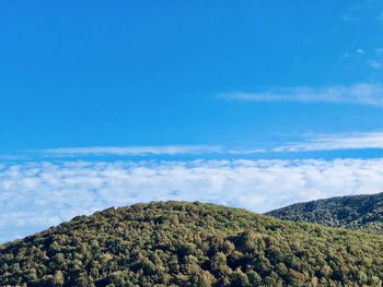 Scenic view of mountain against blue sky