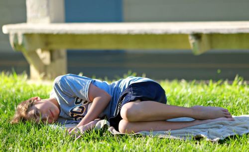Side view of girl lying on grass