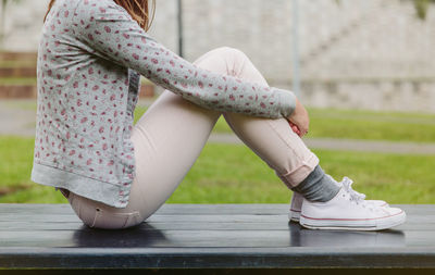 Low section of girl sitting outdoors