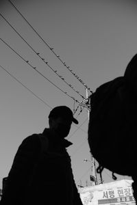 Low angle portrait of man against clear sky