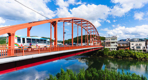 Bridge over river in city against sky