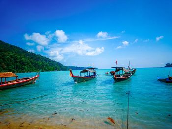 Boats moored in sea against sky