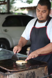 Man cooking street food at market