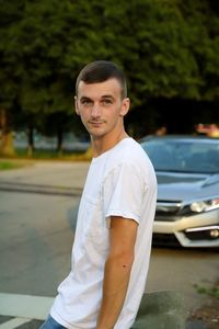 Portrait of young man standing on road