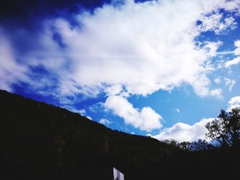 Low angle view of silhouette trees and buildings against sky