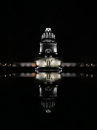 Reflection of illuminated building in water at night