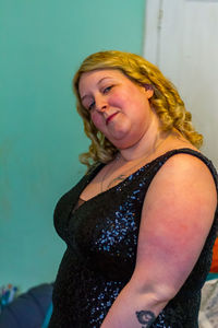 Portrait of woman sitting against wall