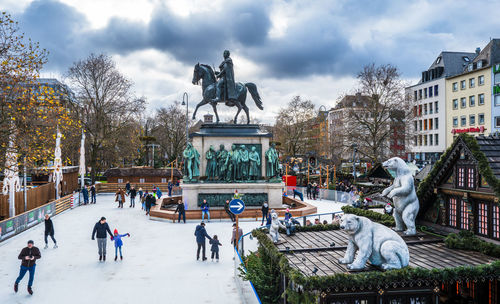 People walking on street against built structures
