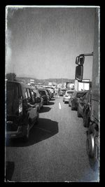 Cars on street by sea against clear sky