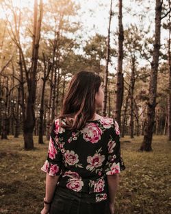 Midsection of woman standing by tree in forest