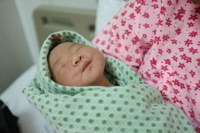 Close-up of baby boy sleeping on bed