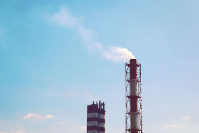 Low angle view of smoke emitting from chimney against sky