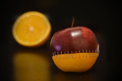 Close-up of apple on table against black background