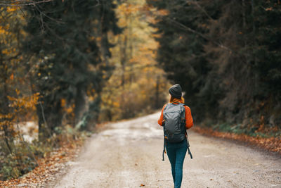 Rear view of man walking on road