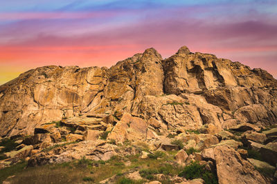 Rock formations on landscape against sky during sunset