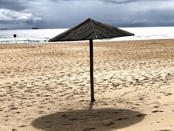 Lifeguard hut on beach against sky