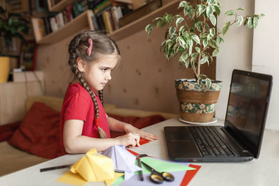 Girl sitting on table at home