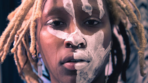 Close-up portrait of young woman with painted face