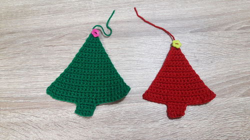 Directly above shot of knitted christmas trees on wooden table