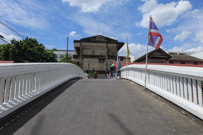 Woman on bridge against building in city