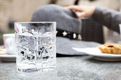 Midsection of woman having drink on table