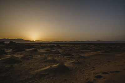 Scenic view of desert against sky during sunset