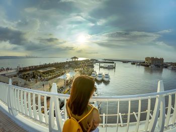 Rear view of woman looking at city against sky