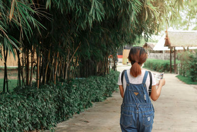 Rear view of woman walking on footpath