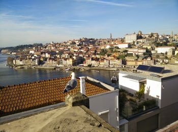 High angle view of townscape by sea against sky