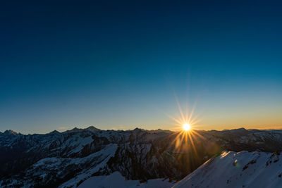 Scenic view of snowcapped mountains against sky during sunset