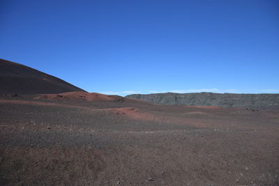 Scenic view of desert against clear blue sky