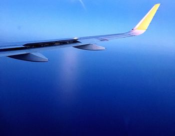 Close-up of airplane wing against clear blue sky