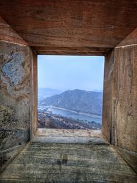 Scenic view of mountains against sky seen through window