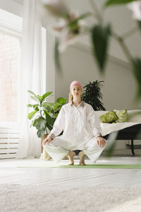 Woman exercising yoga in living room at home