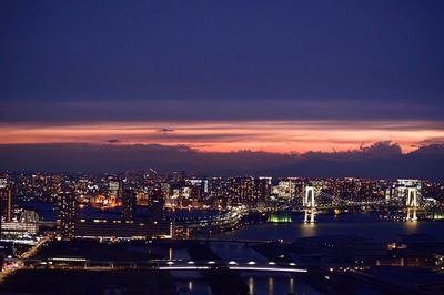 Illuminated cityscape against sky at night