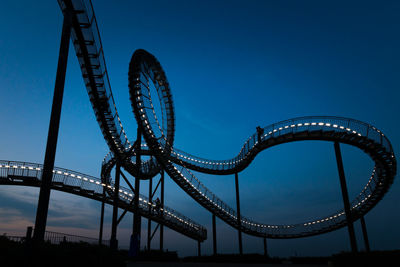 Fragment of walkable tiger and turtle roller coaster sculpture on magic mountain at night