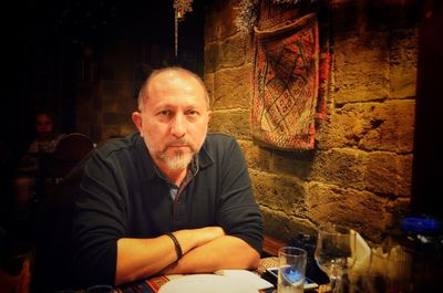 Portrait of a man with drink sitting on table