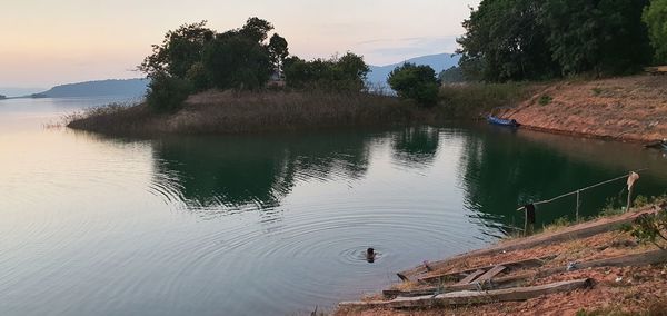 Scenic view of lake against sky at sunset