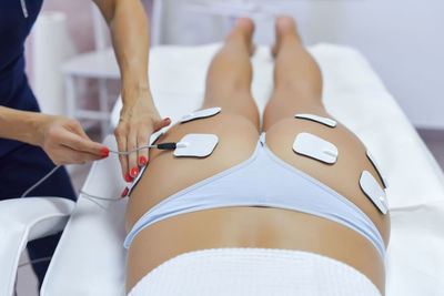 Midsection of woman lying on bed