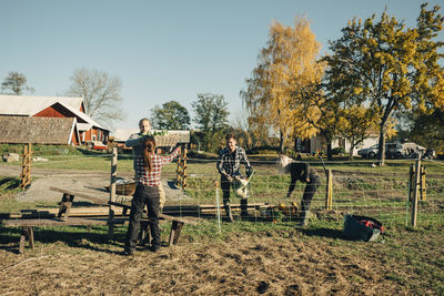 Multi-ethnic male and female farmers with fresh organic vegetables at field