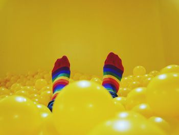 Low section of person in yellow ball pool