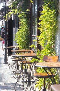 Chairs and tables at sidewalk cafe by building