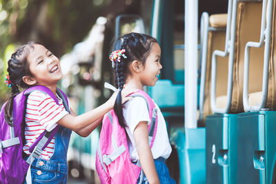 Happy schoolgirls boarding miniature train