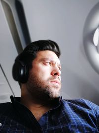 Low angle view of thoughtful mid adult man listening music on headphones