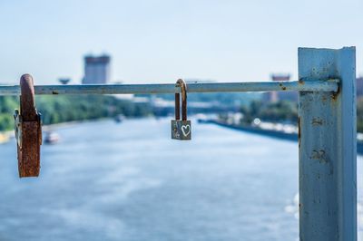 Close-up of padlocks against the lake