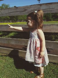 Girl pointing while standing at ranch