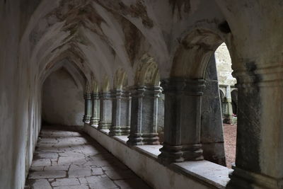 Stone corridor with arched windows in old irish abbey