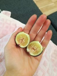 High angle view of hand holding fruit on table