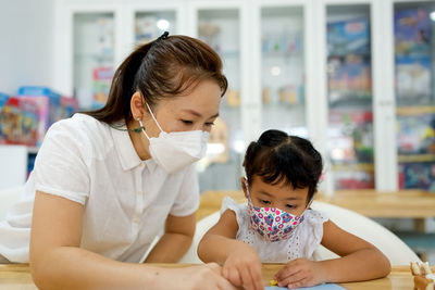 Close-up of mother carrying daughter at home